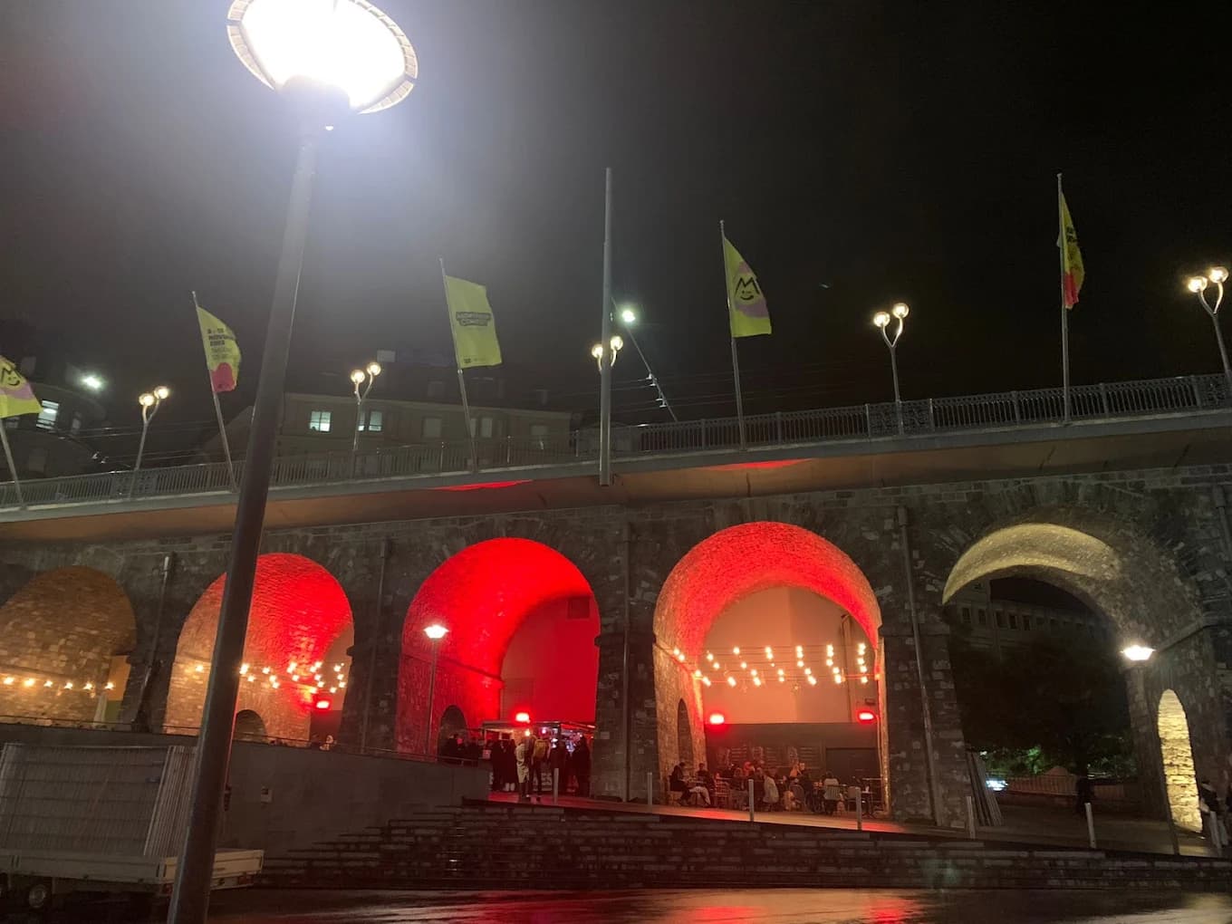 Les voûtes du Grand-Pont éclairées de rouge, terrasse des Arches en soirée, Place de l'Europe à Lausanne.